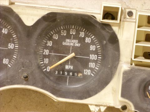 1988 Ford Bronco - A dusty dashboard gauge cluster displays mileage and speed, with a fuel gauge visible on the right.
