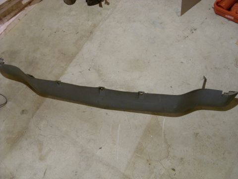 1988 Ford Bronco - A gray plastic car trim piece lies on a concrete floor.