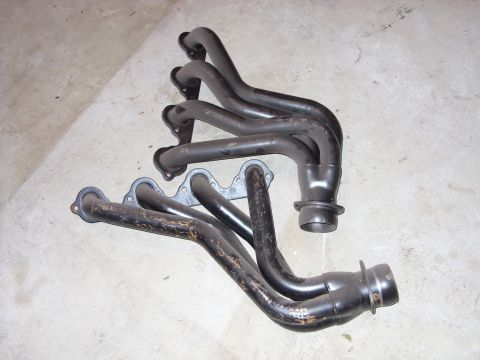 1988 Ford Bronco - Pair of exhaust headers, likely aftermarket performance parts, shown on a floor.