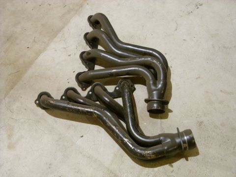 1988 Ford Bronco - A pair of exhaust headers are shown lying on a concrete surface.