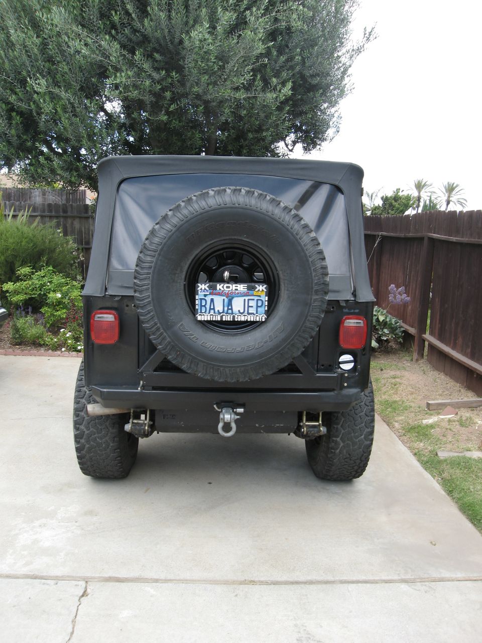 Black Jeep CJ with spare tire on back, custom bumper, and license plate reading BAJA JEP