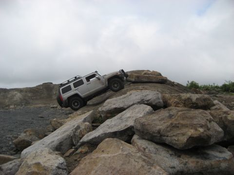 1991 Ford Bronco - This silver SUV navigates a challenging rocky terrain, demonstrating its off-road capabilities.