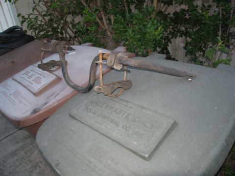 1986 Ford Bronco - Close-up of a metal clamp and hose assembly on a garbage can lid, with text indicating green waste disposal.