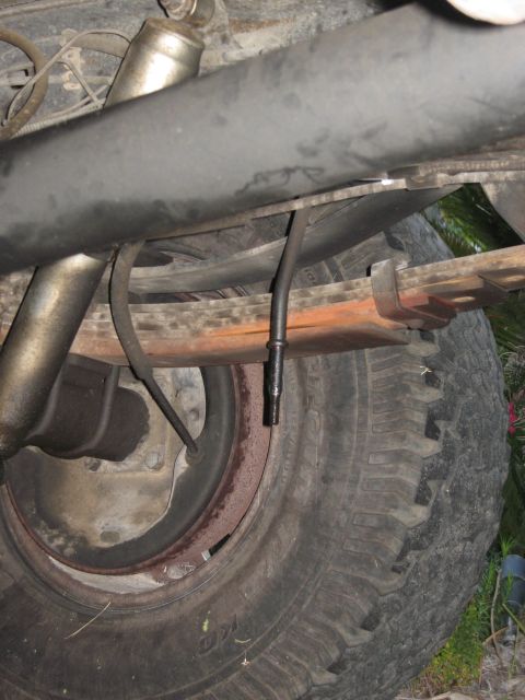 1986 Ford Bronco - Close-up view of the rear suspension components and tire of a vehicle.