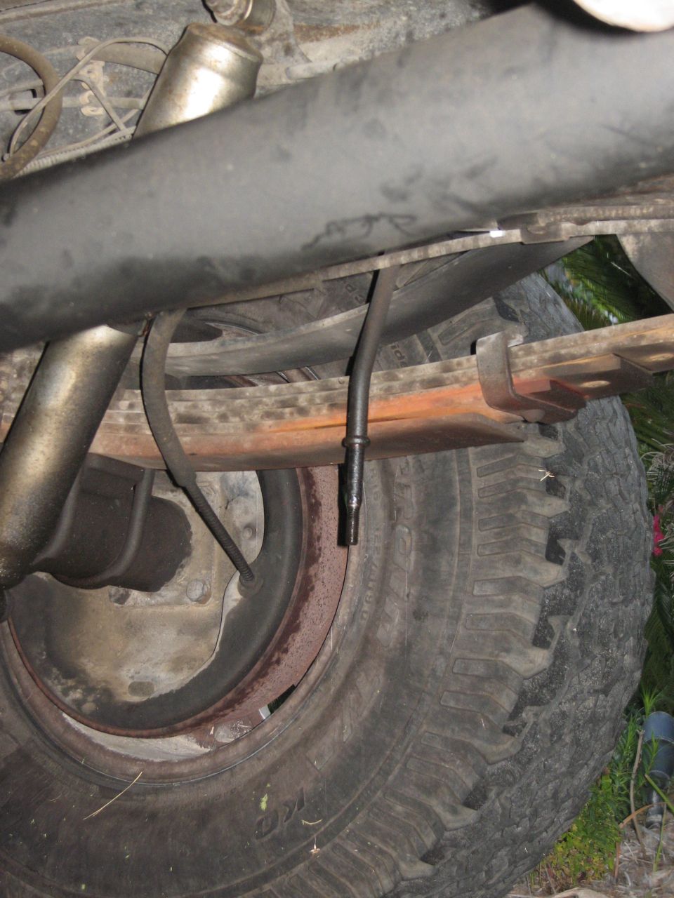 Rear suspension with leaf springs and a tire