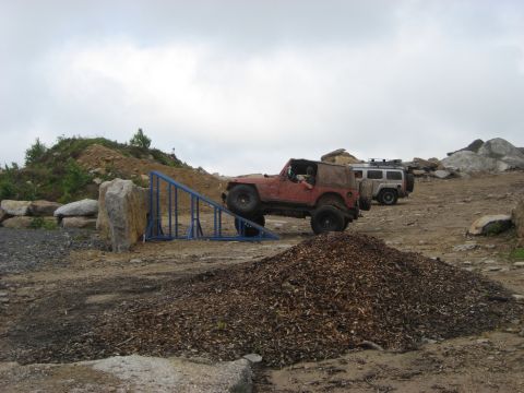1991 Ford Bronco - Two off-road vehicles navigate a challenging course with a ramp and rocky terrain.