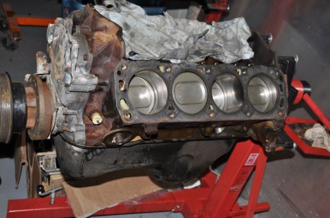 1996 Ford Bronco - Engine block on a stand, showing cylinder bores and front pulley assembly.