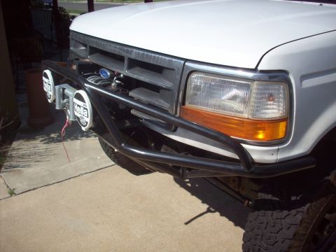 1995 Ford Bronco - Front view of a white Ford F-Series truck with aftermarket off-road accessories.