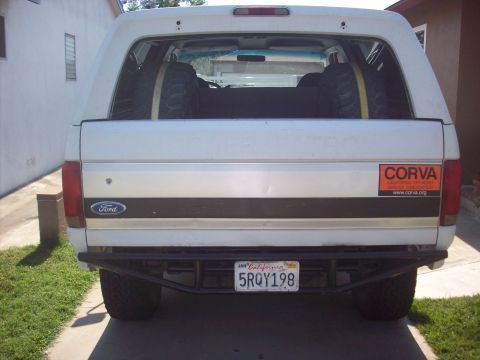 1995 Ford Bronco - This Ford Bronco has a custom rear bumper and spare tires visible through the rear window.