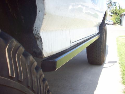 1995 Ford Bronco - Side profile of a white SUV, showing its running boards and off-road tires.