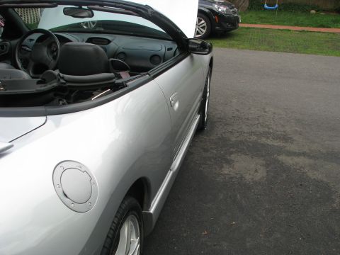2001 Mitsubishi Eclipse - A silver convertible sports car is parked on a driveway, with another vehicle visible in the background.