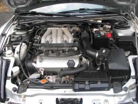 2001 Mitsubishi Eclipse - The engine bay of a car, a V6 engine with prominent "MITSUBISHI" branding on the valve cover.