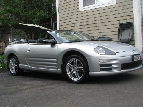 2001 Mitsubishi Eclipse - A silver 2001 Mitsubishi Eclipse convertible with the top down is parked in front of a house.