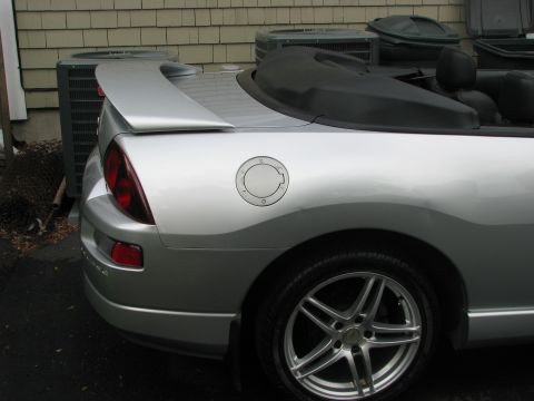 2001 Mitsubishi Eclipse - The rear of a silver convertible sports car is shown with its black soft top up.