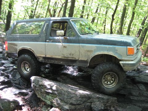 1991 Ford Bronco - This 1991 Ford Bronco navigates a rocky path through a wooded area.