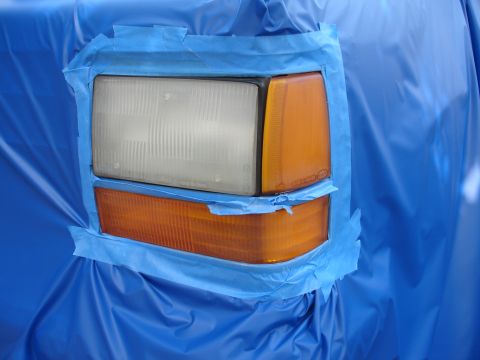1992 Ford Explorer - The headlight and turn signal assembly of a 1992 Ford Explorer is covered with blue sheeting and taped for protection.