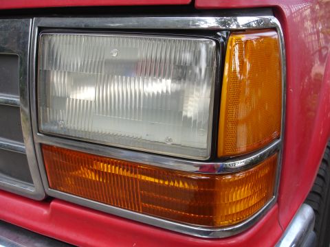 1992 Ford Explorer - Close-up of the front headlight and amber turn signal on a red 1992 Ford Explorer.