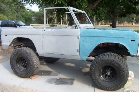 1976 Ford Bronco - This unfinished 1976 Ford Bronco is undergoing restoration, with one fender painted light blue and the rest in primer.
