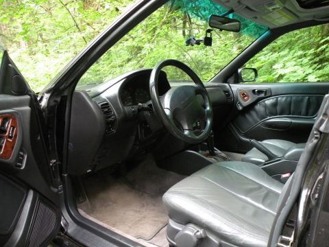 1998 Subaru Legacy - Interior view of a 1998 Subaru Legacy, showing the driver's seat, dashboard, and door panel.