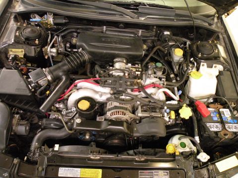 1998 Subaru Legacy - The engine bay of a 1998 Subaru Legacy shows its boxer engine and various components.