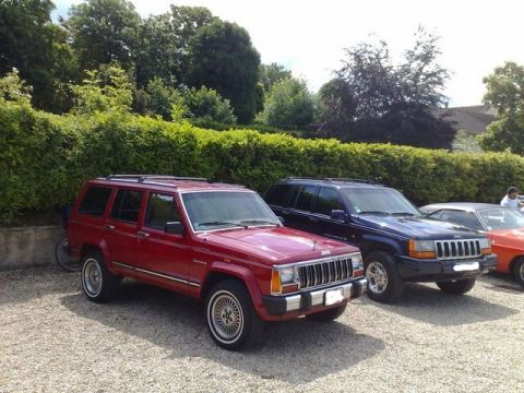 1991 Ford Crown Victoria - Two generations of Jeep SUVs parked outdoors on a gravel lot.