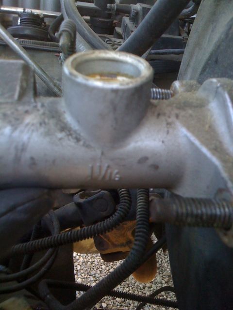 1989 Ford Bronco - Close-up of a brake master cylinder, showing a size marking.