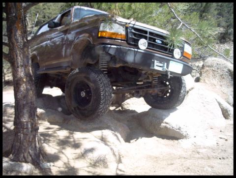 1993 Ford Bronco - A lifted 1993 Ford Bronco navigates a rocky off-road course.