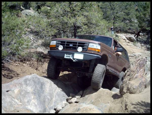 Brown 1993 Ford Bronco navigating a rocky off-road trail
