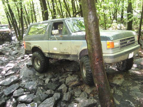 1991 Ford Bronco - A 1991 Ford Bronco navigates a challenging rocky trail during an off-road event.