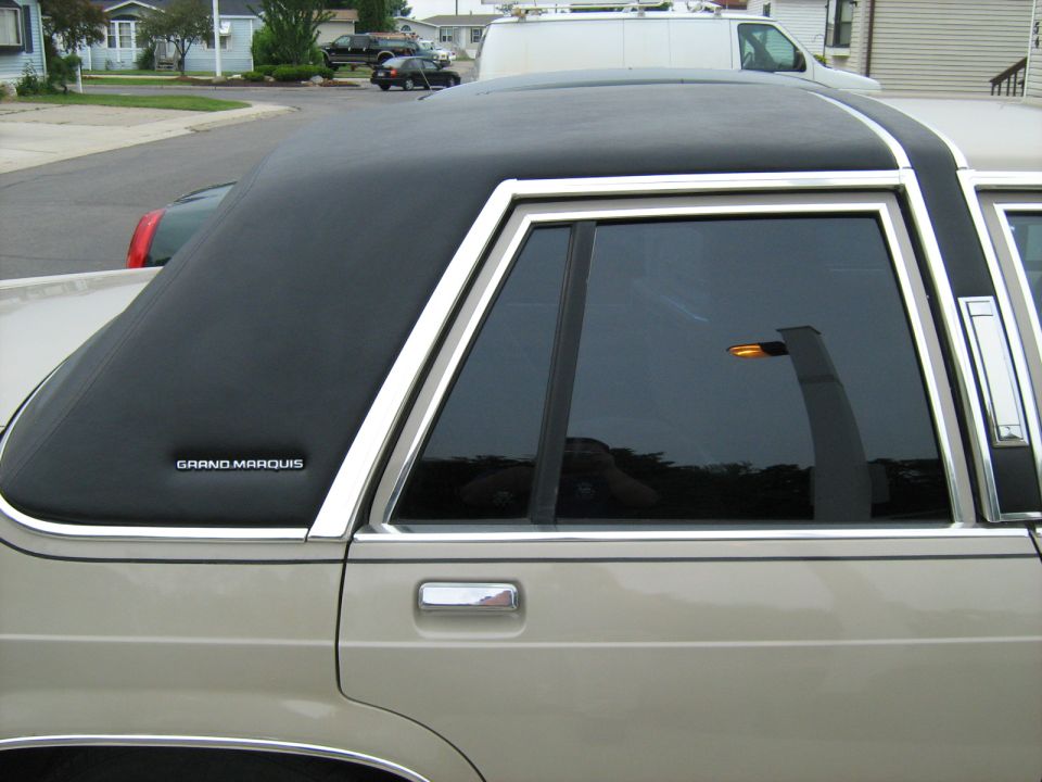 Tan Mercury Grand Marquis with a black vinyl top, side view