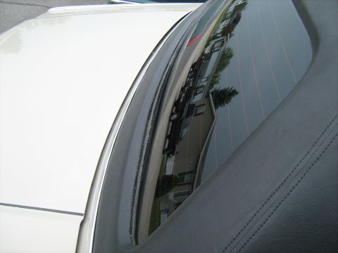1988 Mercury Grand Marquis - Reflection in the rear window shows houses and another vehicle on the street.