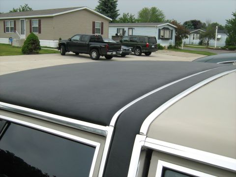 1988 Mercury Grand Marquis - The foreground shows a car's vinyl roof, while two trucks and an SUV are parked in the background.