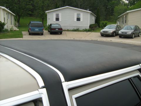 1988 Mercury Grand Marquis - A vinyl-top sedan, likely a 1988 Mercury Grand Marquis, is seen in a residential setting with multiple other vehicles present.