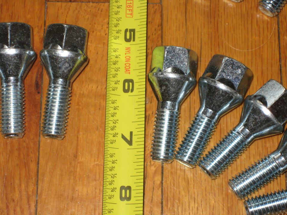 Lug nuts and a tape measure on a wooden surface