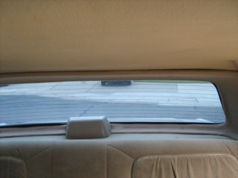 1988 Mercury Grand Marquis - View from the back seat of a 1988 Mercury Grand Marquis, showing the interior and the exterior through the rear window.
