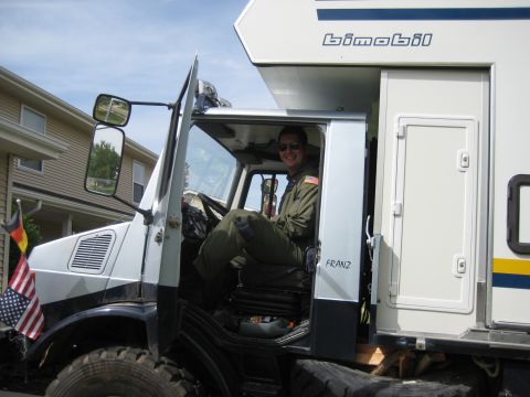 1995 Ford Bronco - Man in pilot uniform sits in the cab of a large truck with a camper body. The name 'FRANZ' is visible on the door.