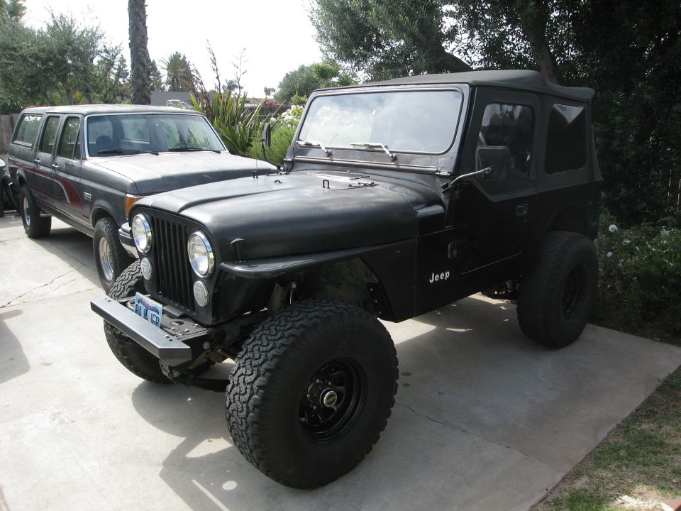 Black Jeep CJ parked next to a gray Ford Bronco