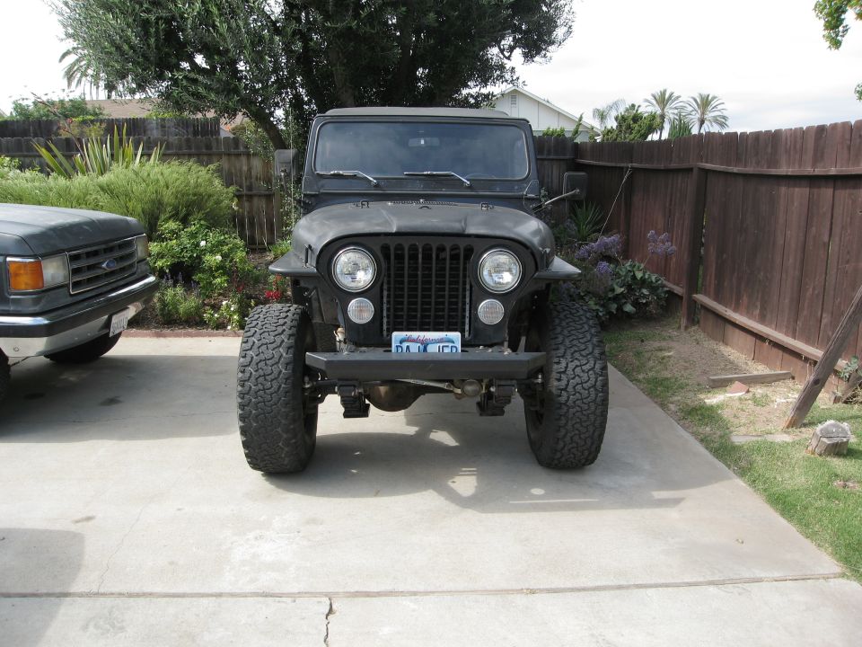 Black Jeep CJ parked next to a dark gray Ford truck