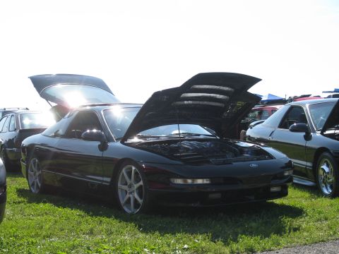 1994 Ford Probe - Two black Ford Probes are parked on grass, both with their hoods open.