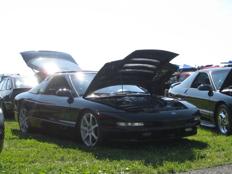 Black 1994 Ford Probe with hoods open, parked on grass next to another car