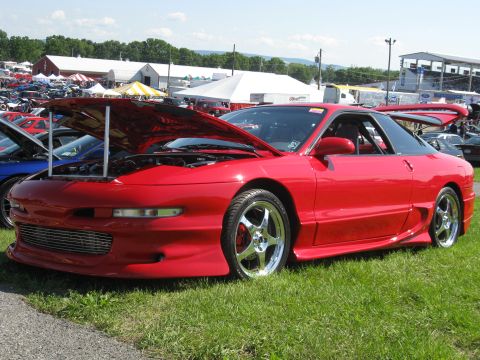 1994 Ford Probe - Red 1994 Ford Probe on display at a car show with other vehicles in the background.