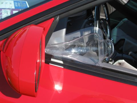 1994 Ford Probe - A clear plastic wind deflector is installed on the driver's side window of a red car.