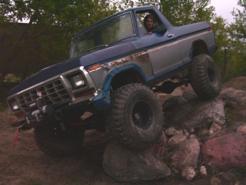 1978 Ford Bronco - A blue and silver 1978 Ford Bronco navigates a rocky obstacle course.