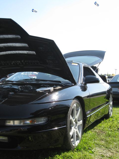 1994 Ford Probe - A black 1994 Ford Probe is displayed with its hood and trunk open, revealing the engine and interior space.