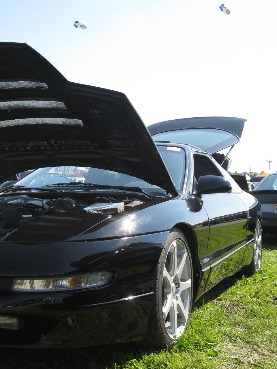 Black 1994 Ford Probe with hood and trunk open, front 3/4 view