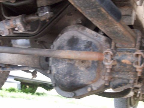 1995 Ford C-350 (Centurion Conversions) - Close-up of the rear axle assembly and related suspension parts on a vehicle.