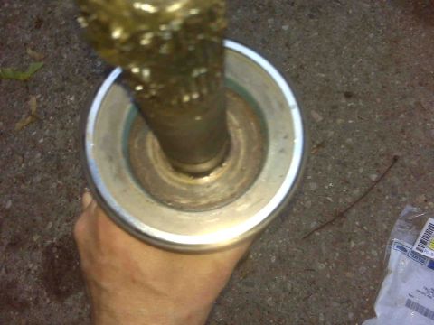 1995 Ford Bronco - Close-up view of an axle part, with packaging and a thin wire on the ground.