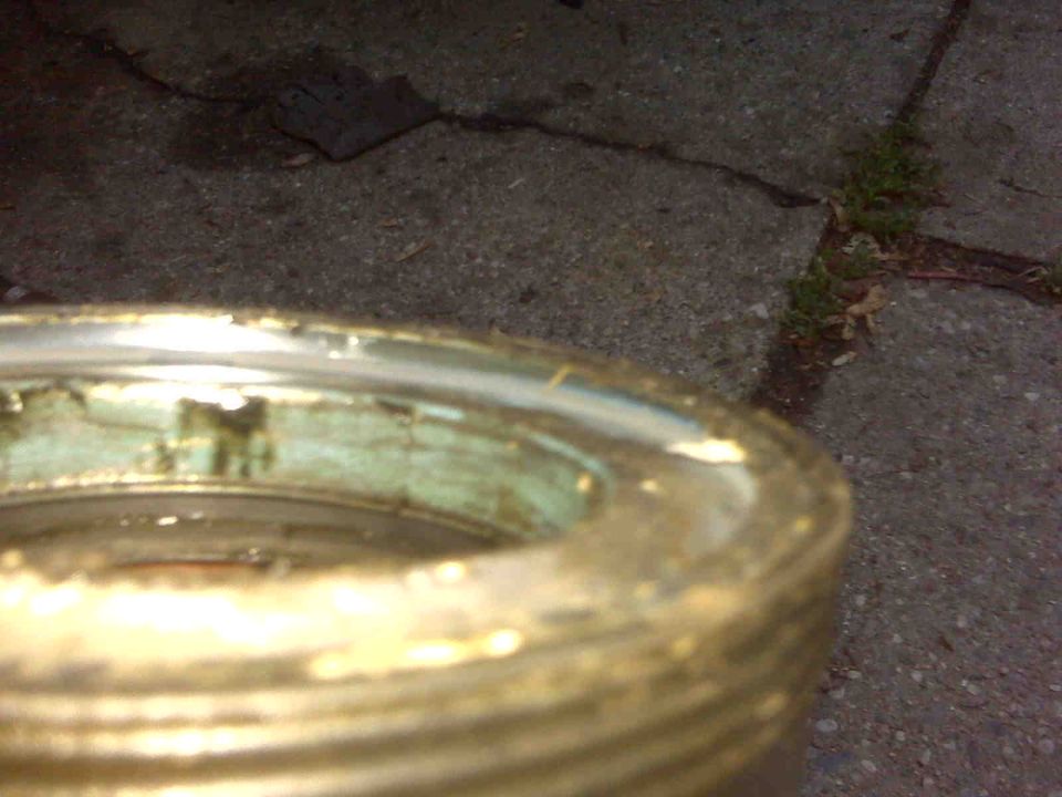 Close-up of a gold-colored wheel hub with green corrosion and visible damage