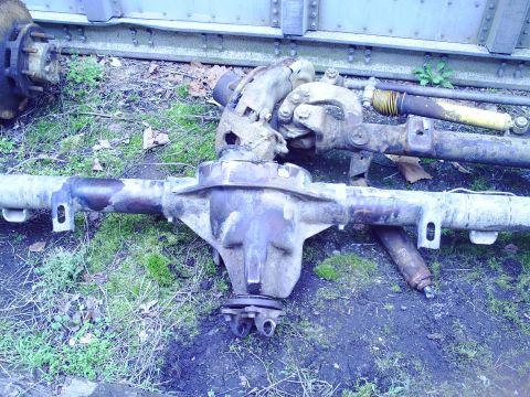1990 Ford Bronco - Vehicle axles and suspension parts are shown on the ground, with a watermark for Supermotors.net.