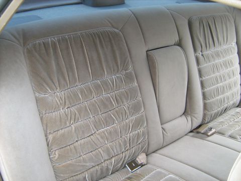 1988 Mercury Grand Marquis - Interior view of tan velour rear car seats with a pleated pattern and visible seatbelts.